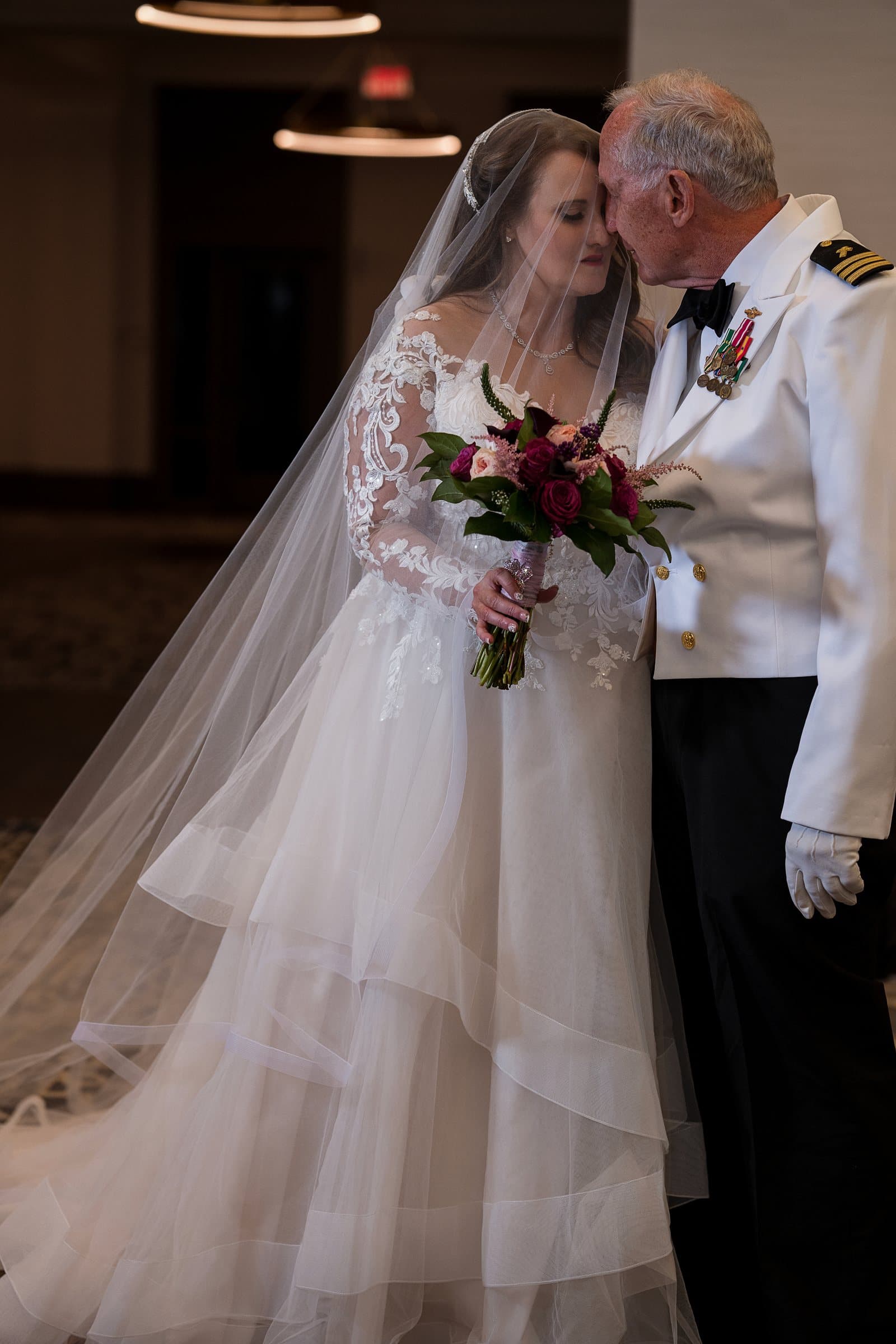 Kimberly and Robert forehead to forehead, his Navy dress whites and her lace veil