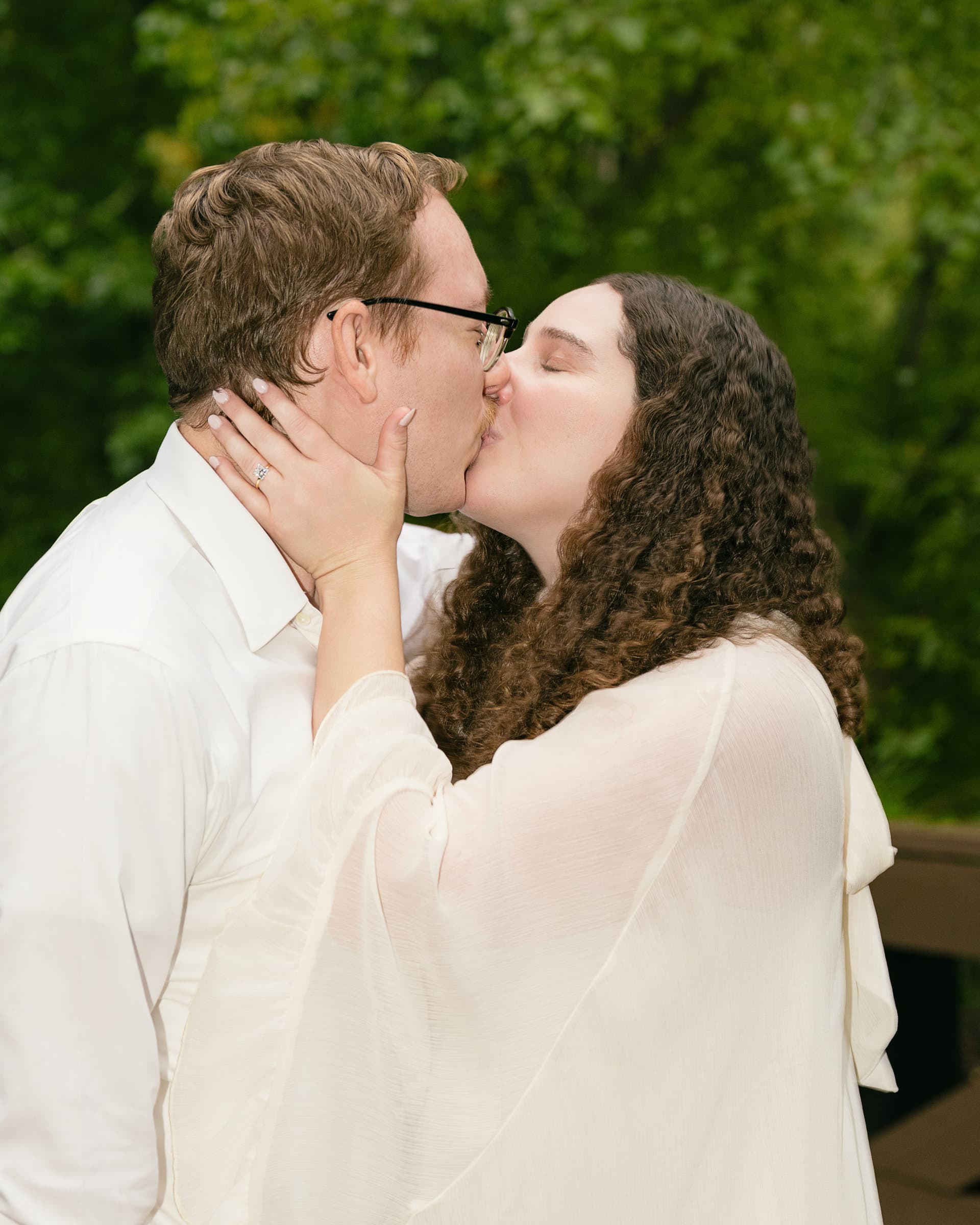 Luan and Sarah kiss beneath the trees after the proposal