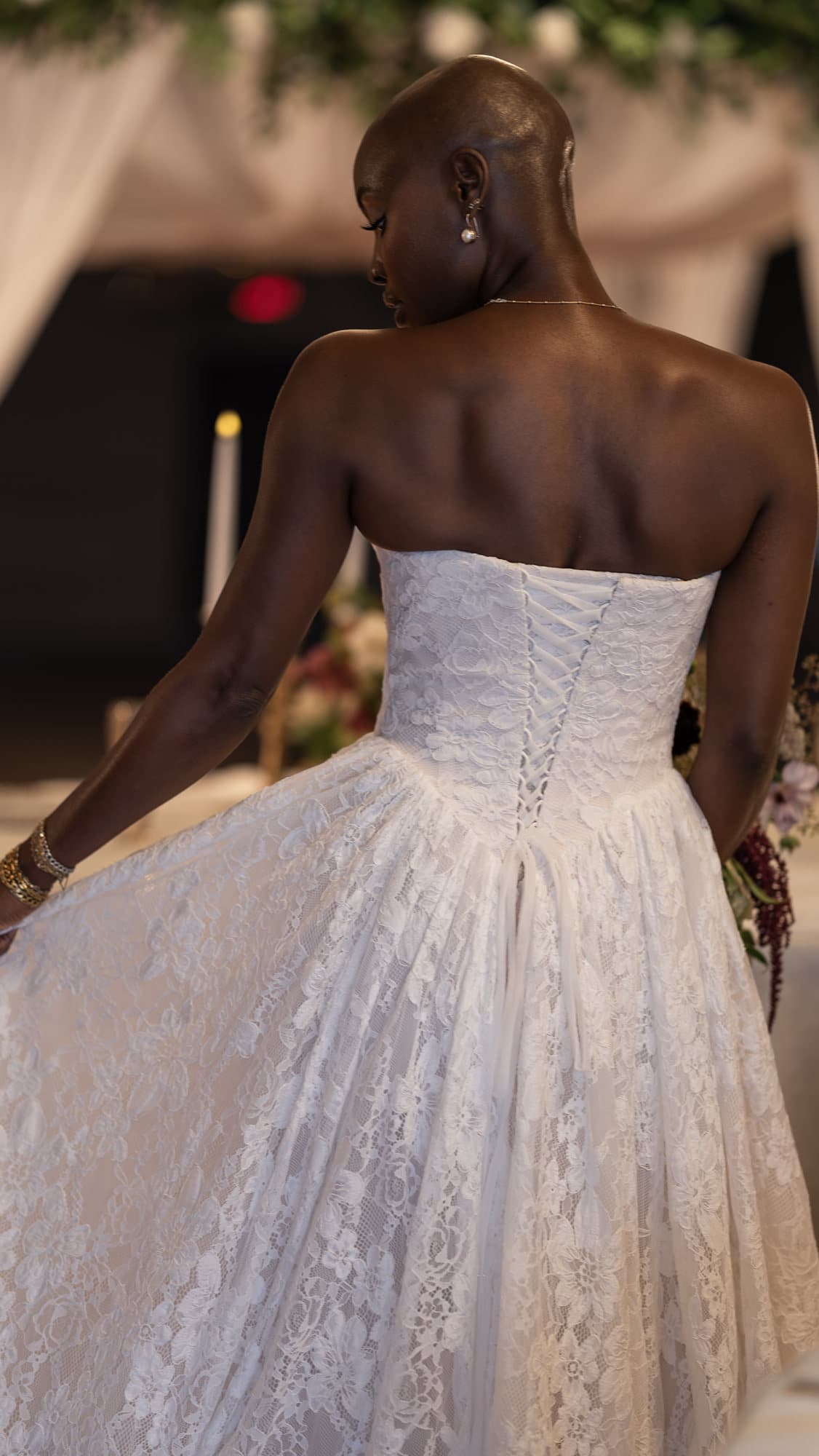 Bride from behind beneath the floral canopy