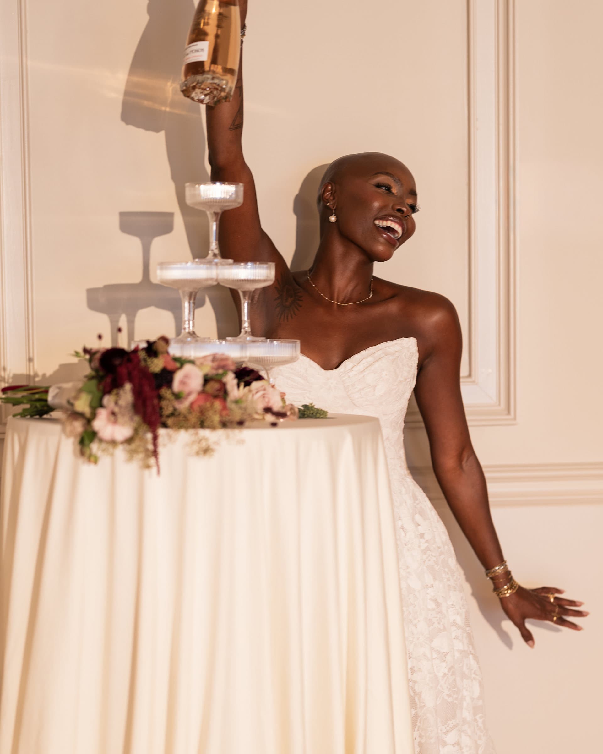 Bride laughing as she pours the champagne tower