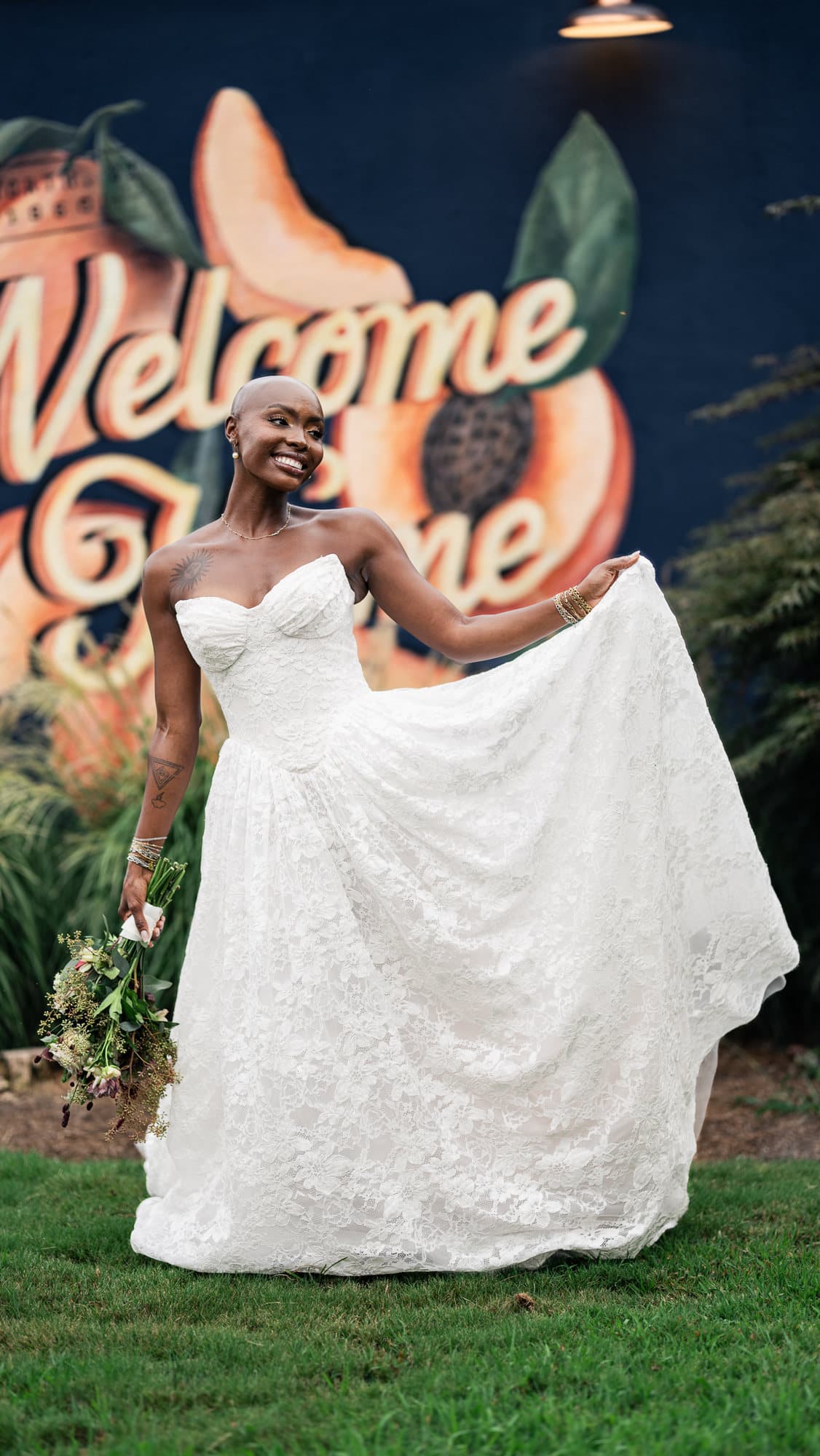 Bride swinging her gown before the Welcome Home mural
