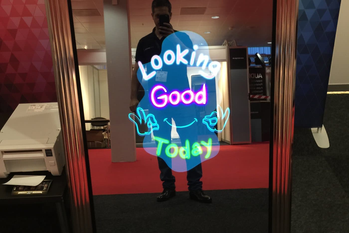 The mirror booth on an expo floor showing an animated on-screen greeting