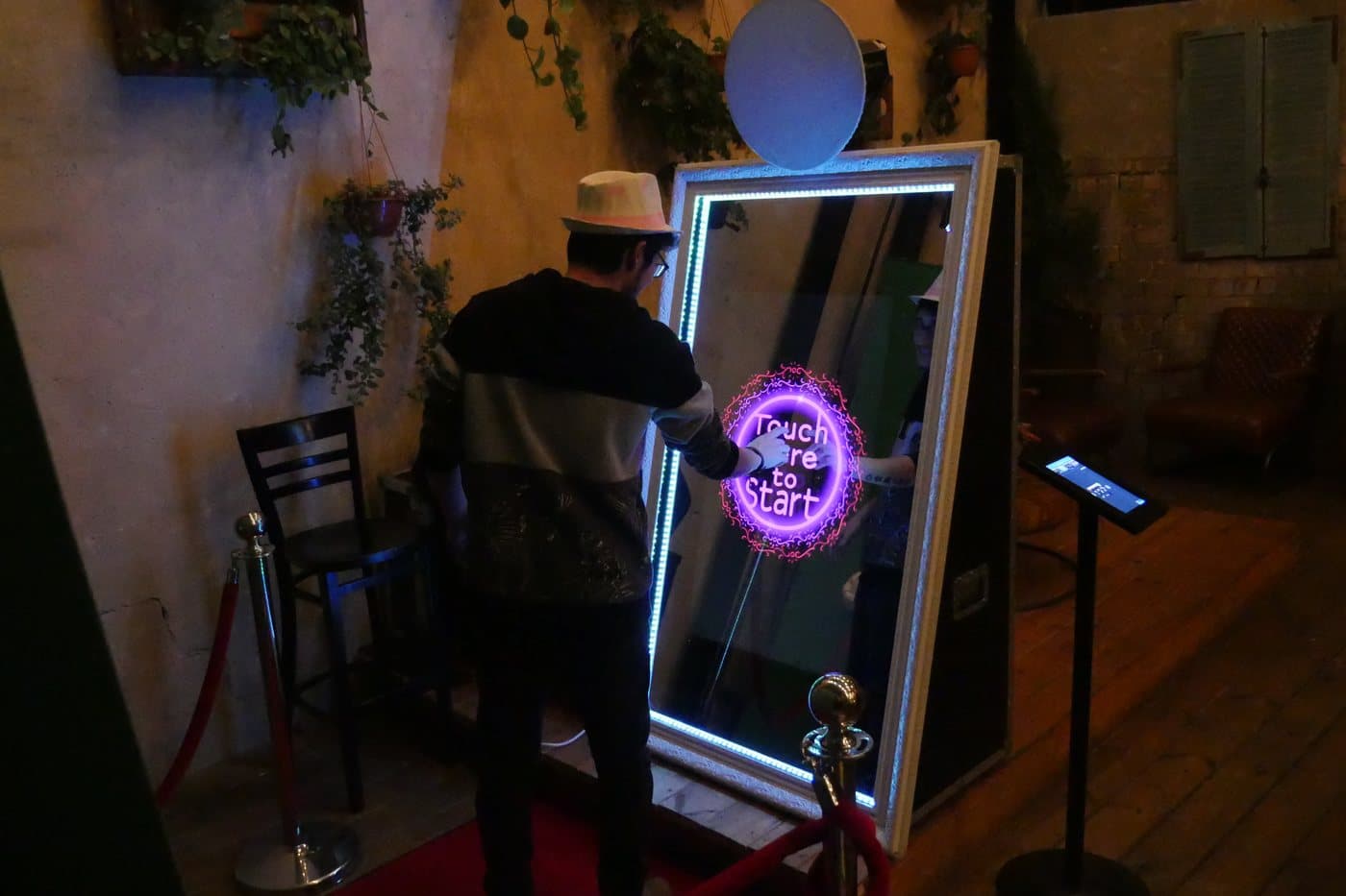 A guest posing at the lit mirror booth during a corporate event