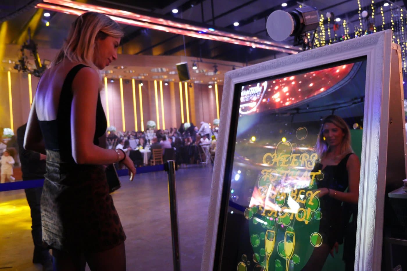 Guests gathered around the mirror booth at a reception